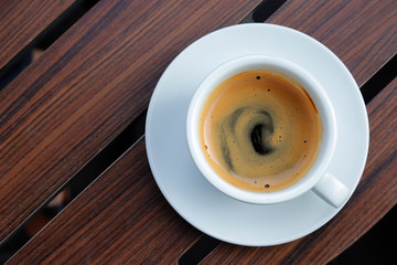 Hot coffee on wood background.