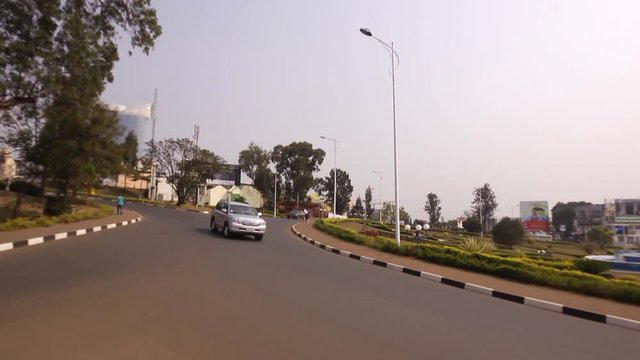 Traffic circle, roundabout, cars, motorbikes, motorcycles driving on a road in Kigali, Rwanda 