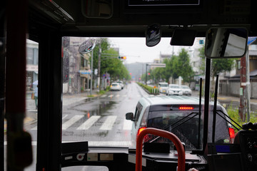 雨のバスフロントガラスからの景色