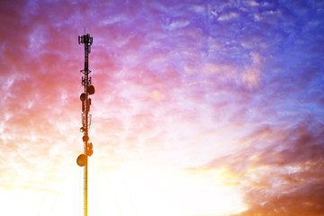Telecommunication tower antenna at clouds sunset sky background