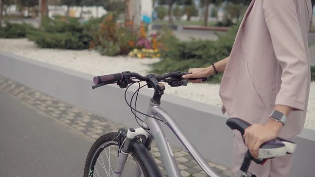 Woman walking alone by bicycle.