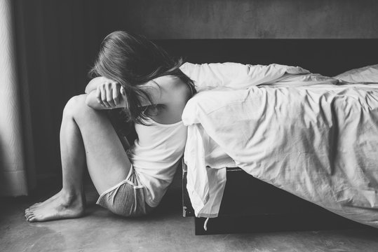 Depressed Woman Sitting Alone In Bedroom.