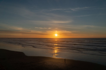 Man walking on the beach during sunset on the Oregon coast
