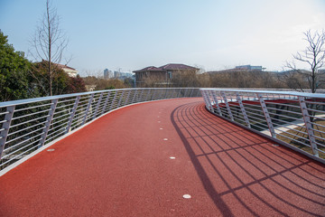 Rubber track under modern steel bridge