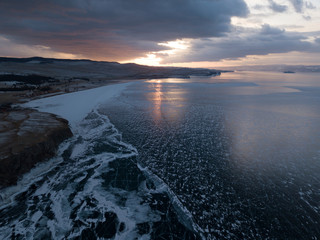 Aerial shot of Olkhon island on sunset in winter. Frozen lake Baikal. Ice and snow. Abraham Lake, Lake Superior.