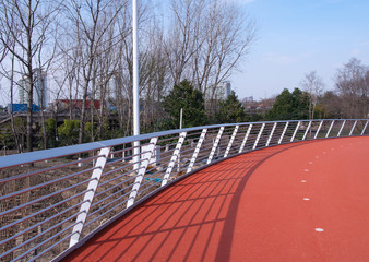Rubber track under modern steel bridge