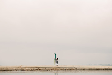 Female surfer with long board on the sea silhouette