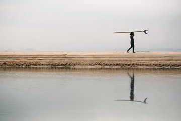 male surfer with long board on the sea silhouette