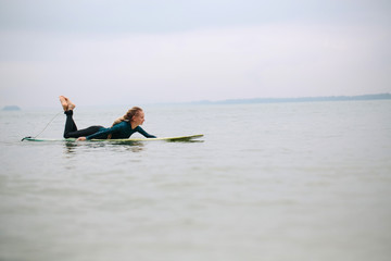 Female surfer puddling in the ocean