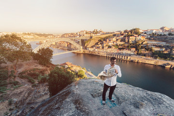 Musician playing the trumpet. European city view with bridge on background