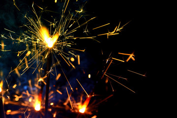 Firework background / A sparkler is a type of hand-held firework that burns slowly while emitting colored flames, sparks, and other effects