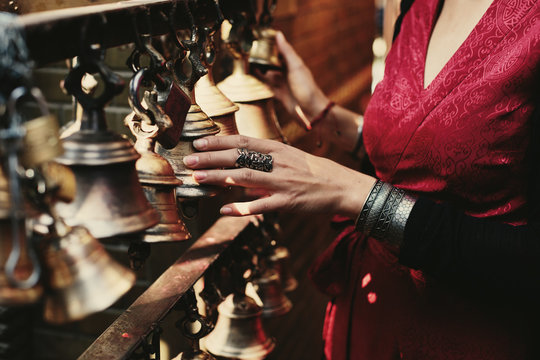 Woman hand touching buddhist bells in Nepali temple