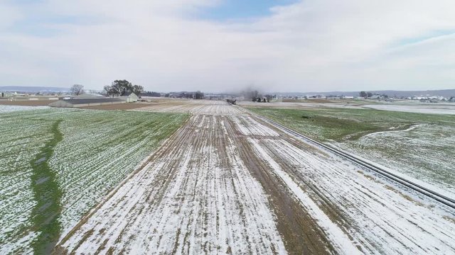 Ariel View of Thomas the Train and Passenger Cars Puffing Smoke Along Amish Farm Lands After the First Snow of the Season