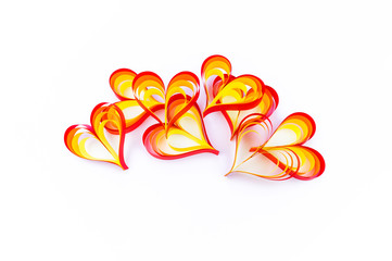 Heart made of paper of red orange and yellow color. White background.