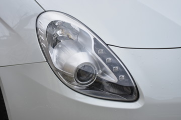 shiny headlights on a white silver car