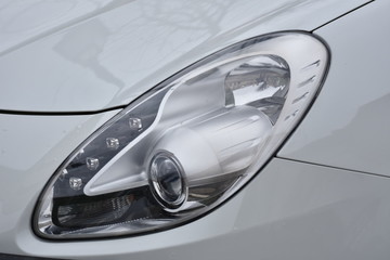 Obraz na płótnie Canvas shiny headlights on a white silver car