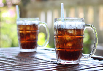 glass of water with ice cubes on wooden table