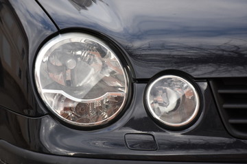 Car'sCar exterior detail.shiny headlight on a black  car exterior detail, headlight on a  new car