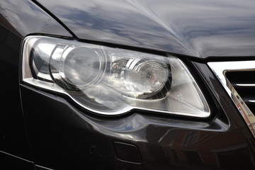 Car'sCar exterior detail.shiny headlight on a black  car exterior detail, headlight on a  new car