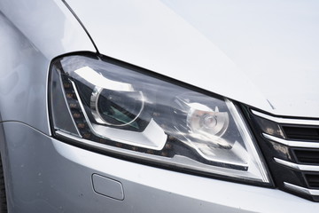 Car's exterior detail, headlight on a  silver car