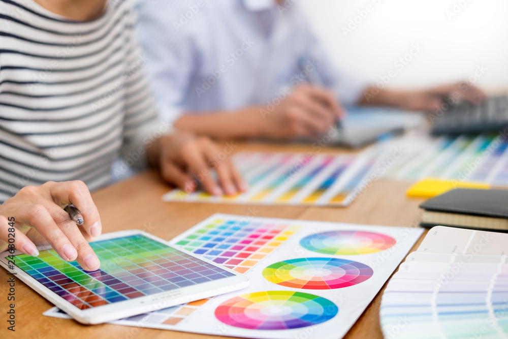 Poster designer graphic creative creativity working together coloring using graphics tablet and a stylus at