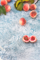 Natural texture of homemade fruit. Ripe juicy peaches on a blue background cut in half with a bone. Close up and copy space