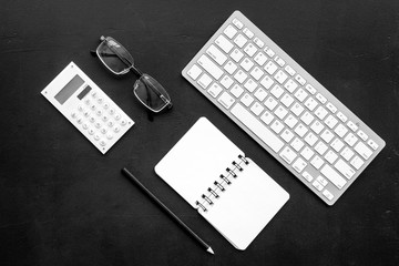 Office desk in order. Geometry. Computer keyboard and office supplies, glasses on black background top view space for text