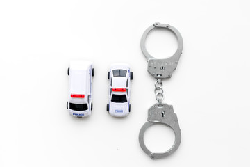 Police concept. Police car toy and handcuff on white background top view copy space