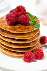 stack of pancakes with fresh raspberries for breakfast, vertical closeup