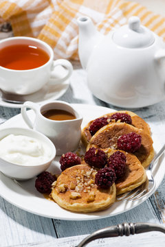 sweet corn pancakes with berries and caramel sauce on white table
