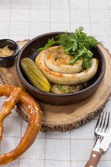 grilled sausages, served with beer, pretzels, pickles and mustard on the side for Octoberfest on textile background