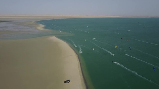 Drone shot of kiteboarders surfing on the coast of Dakhla, Morocco