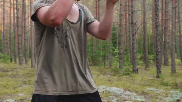Two white male martial artists practicing kicks to the body in a Latvian pine forest.