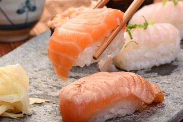 Chopsticks picking up salmon sushi    