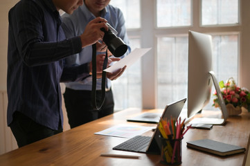 Photographer Colleagues discussing photographs at creative office, Photo editor job.