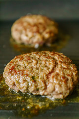 cooking meat burgers with spices on grill at home. Close up, selective focus