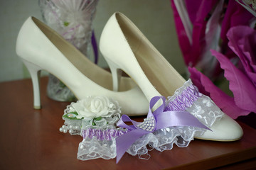 white high-heeled shoes and garter of the bride