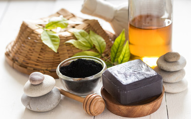Black spa soap made from activated charcoal and honey on white wooden background, facial and body cleansing product