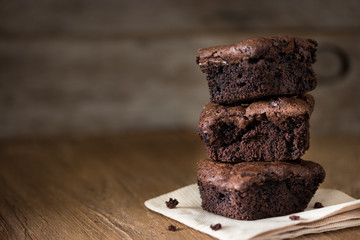 A stack of chocolate brownies on wooden background, homemade bakery and dessert
