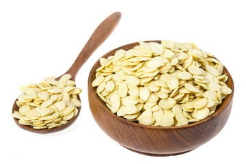 Raw watermelon seeds in a wooden bowl isolated on white backgroun