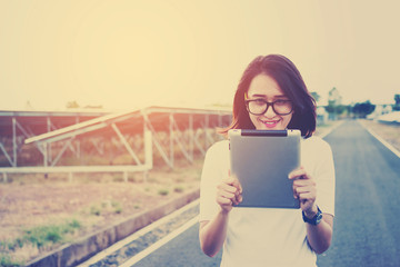 women engineer working on checking and maintenance equipment at green energy solar power plant:...
