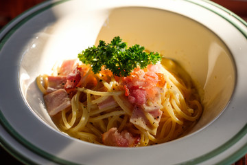 Spaghetti Carbonara with bacon, ham and vegetable in bowl