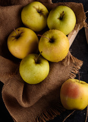 Ripe appetizing apples with burlap. Cinnamon, apples, burlap, table, knife. Fruits.