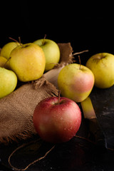 Ripe appetizing apples with burlap. Cinnamon, apples, burlap, table, knife. Fruits.
