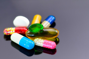 Colorful of oral medications on dark background.