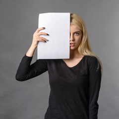 girl hides her face behind blank blank white sheet