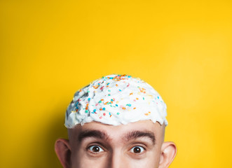 Emotional portrait of surprised bald man with easter cake on his head. Funny Happy Easter concept....