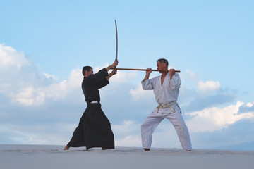 Concentrated men, in Japanese clothes, are practicing martial arts