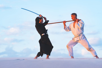 Concentrated men, in Japanese clothes, are practicing martial arts