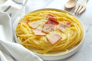 Close up of spaghetti carbonara on white plate.